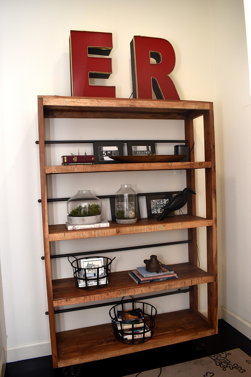 The master bedroom is decorated with a shelving unit. The E and R are Heer and Benioni’s first initials.
