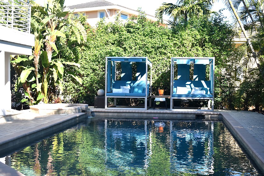 The pool area is surrounded by trees, giving the yard privacy.