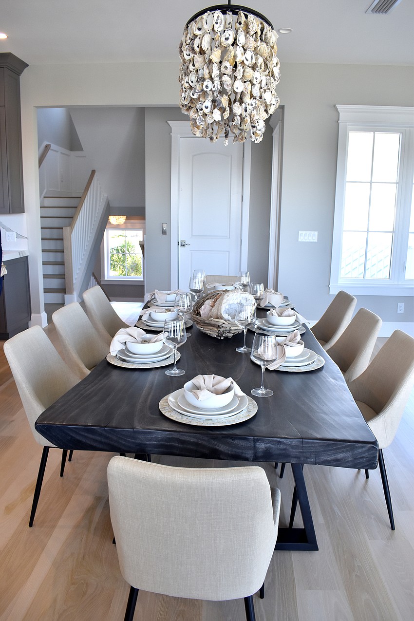 The dining room chairs match the color of the living room couch.