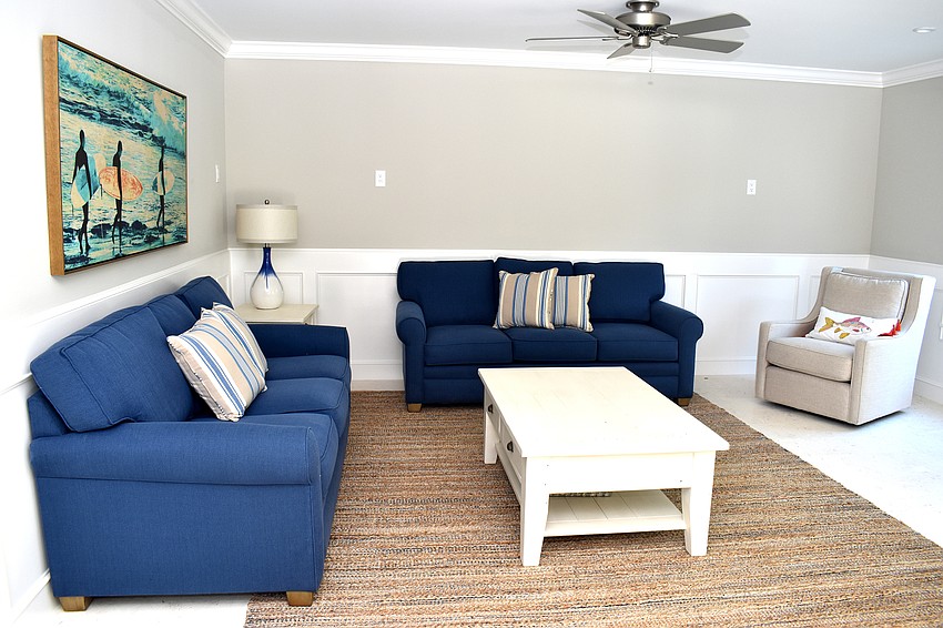 A living room area is on the bottom floor that walks out to the pool deck.