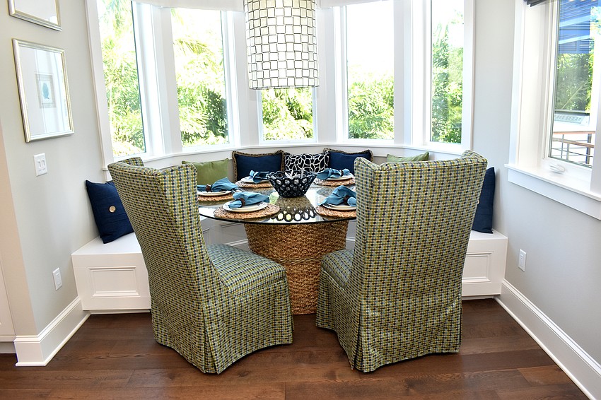 A second table is set against a bay window with green accents.