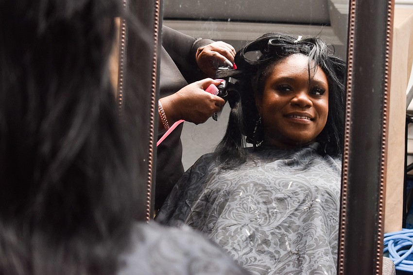Shantel Norman looks in the mirror as she gets her hair done.