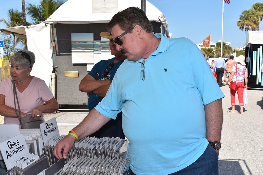 Mike Maiore thumbs through caricature art.