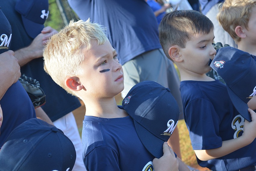 Jackson Lacy, who plays on the Brewers team, stands for the national anthem.