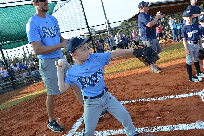 Rays' player Reed North, 5, catches the ceremonial first pitch of the season and throws it back to the pitcher, Jackson Lacy.