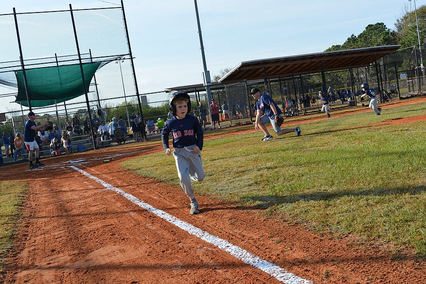 Six-year-old Red Sox player Yale Ewert makes it to first base on his first bat of the season.