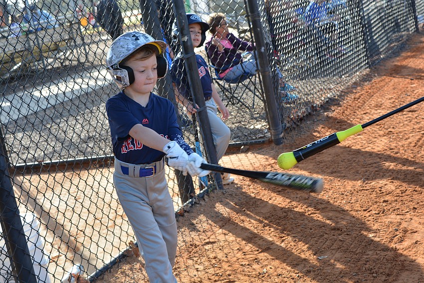 Five-year-old Hudson Garcia warms up on deck before his first at bat.