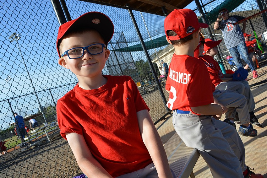 Six-year-old Angels player Trevor Farrelly is all smiles as he waits for his turn at bat.