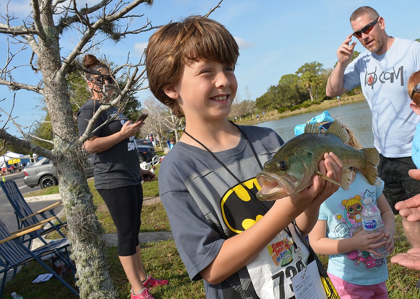 Sarasota's Kai Gilliam shows off the 17-inch bass he caught with a shiner.