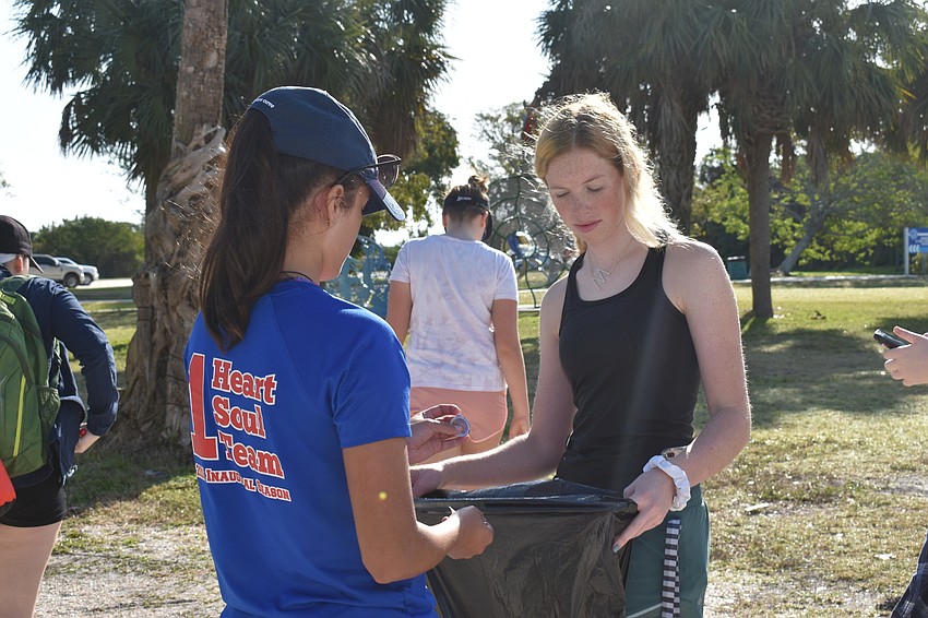 Andrea Soto handed Mairead Studdiford some litter she picked up.