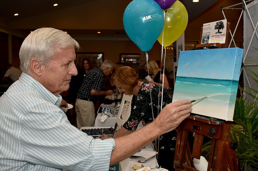 Alan Zawacki paints a beach scene during the event.