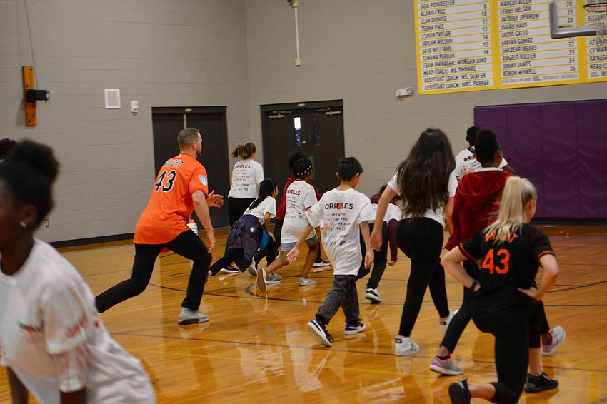 Orioles team members particpated in warm up exercises with the students prior to starting the fitness stations.