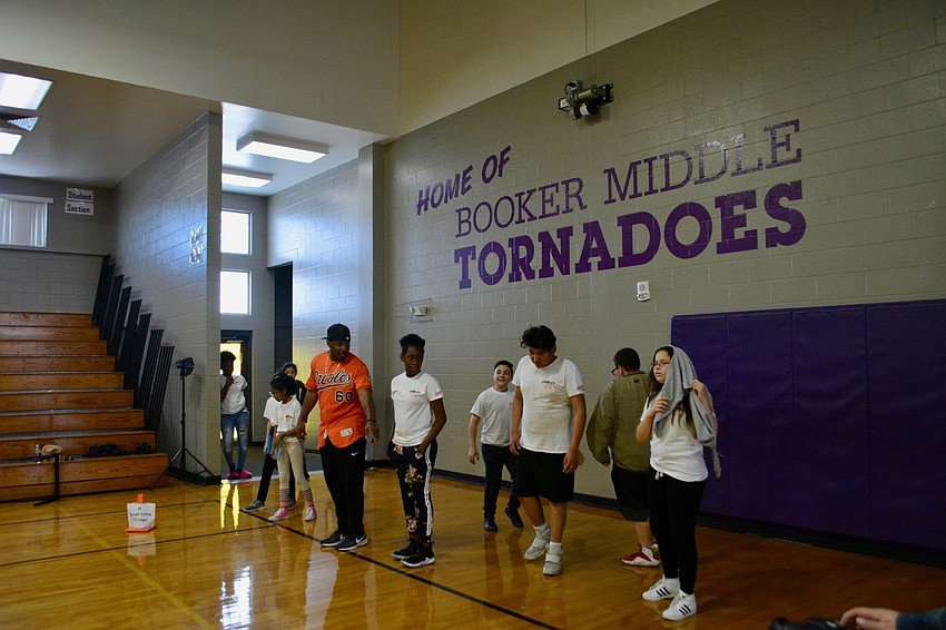 Mychal Givens does lunges with students.