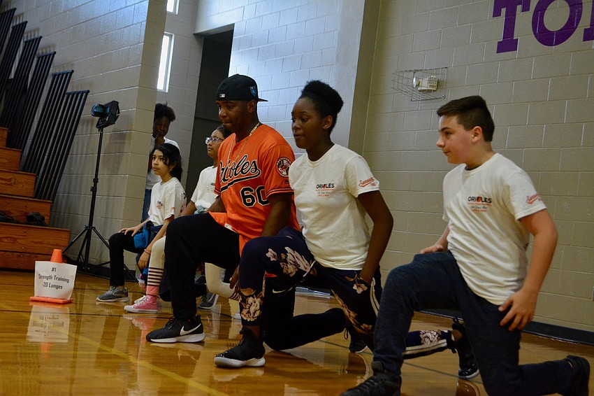 Mychal Givens does lunges with students.