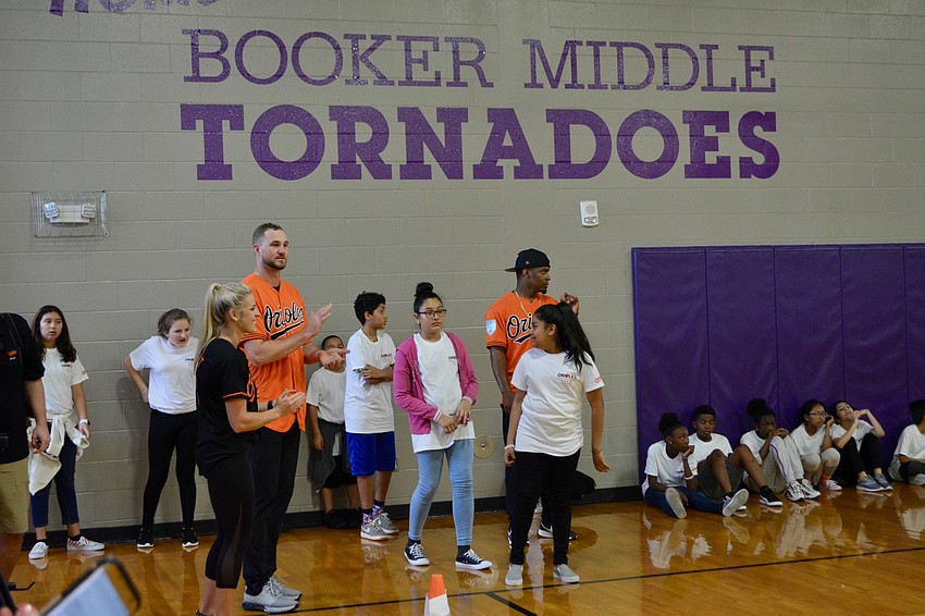 Mychal Givens (right) and Mike Wright Jr. (left) cheer students on through their final relay race.