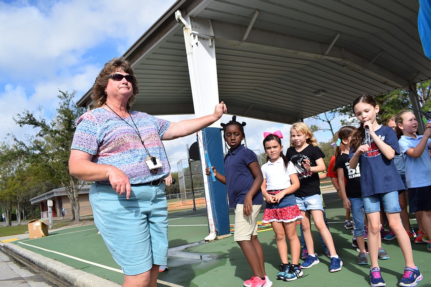 Coach Penny Stilson corrals the first-graders and passes out ice pops after they finish their route on the Walk-A-Thon.