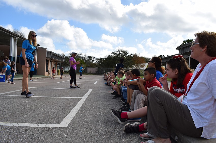 First-graders at Braden River Elementary all sit on the curb and take time to cool down with ice pops at the