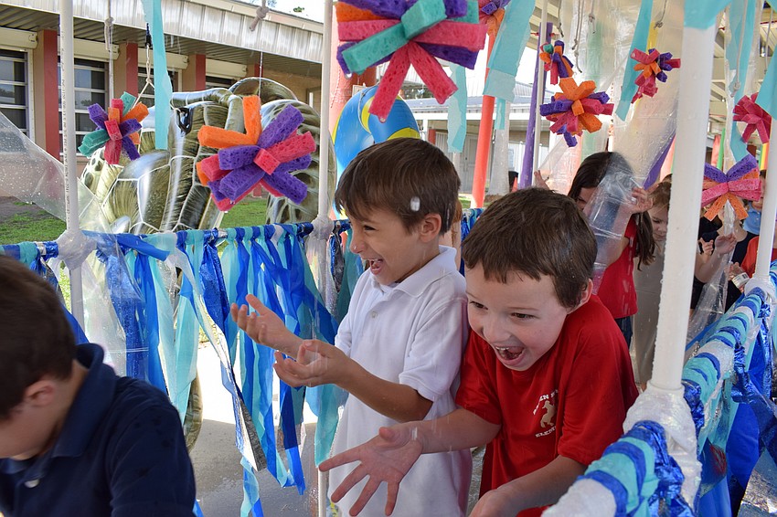 Kindergartner's rush through the water tunnel with excitement at the end of the Walk-A-Thon's route.