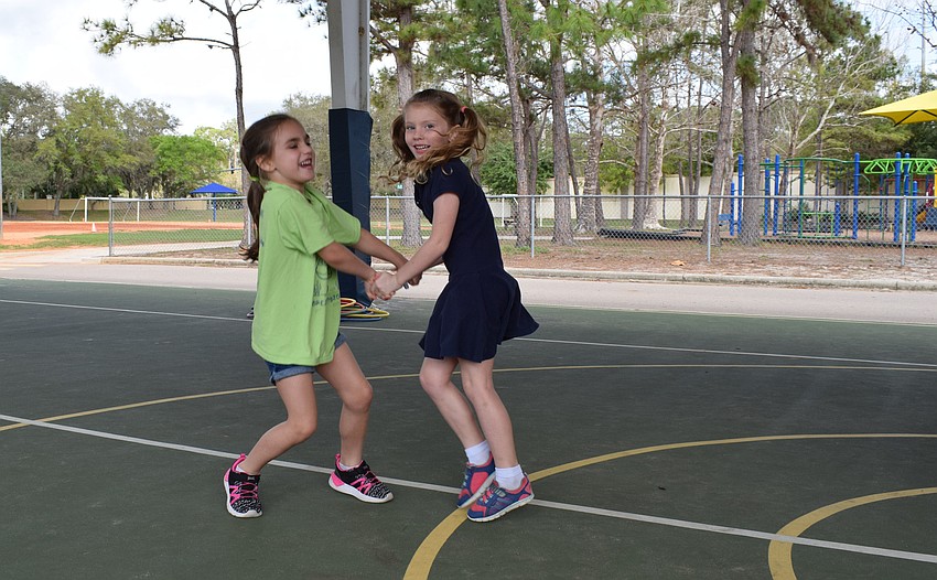 Kindergarten students in Carol Colesa's class, Tayeena Cintron and Emilia Notarianni, dance with excitement before the Walk-A-Thon begins.