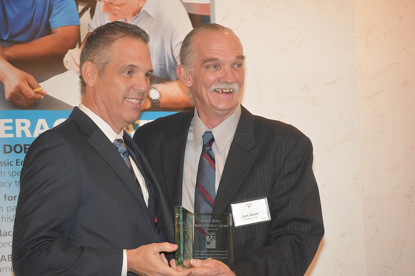 Vincente Medina awards Children First representative Jack Baker with the James E. Duffy Friend of Literacy Award.