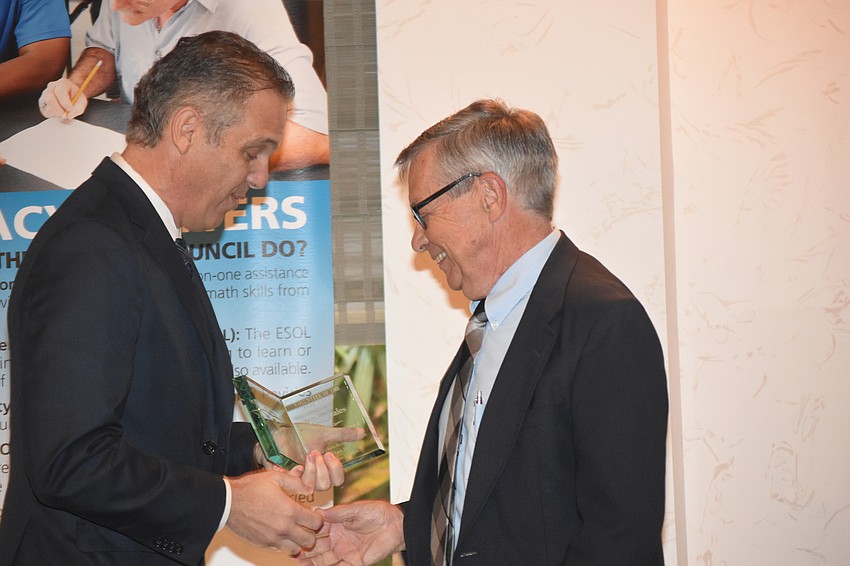 Vincente Medina awards Roger Eales with the Volunteer of the Year award.