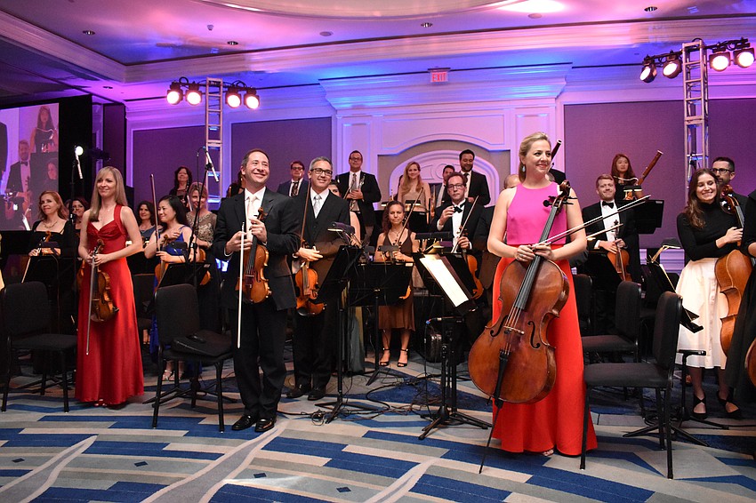 The orchestra stands to be recognized after the performance.