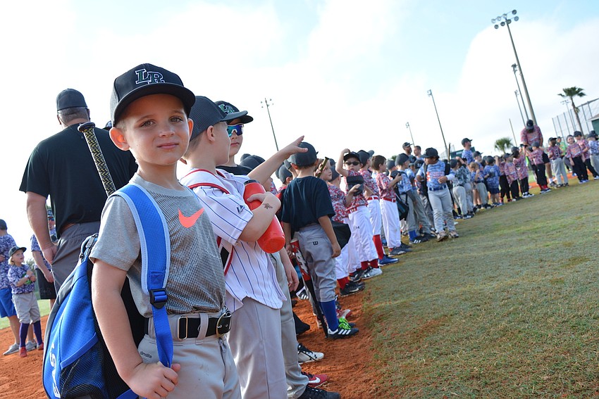 Lakewood Ranch Little League 6-year-old Kallen Terry lines up for team introduction during opening ceremonies. He's playing on the Innovative Answering Assistance team.