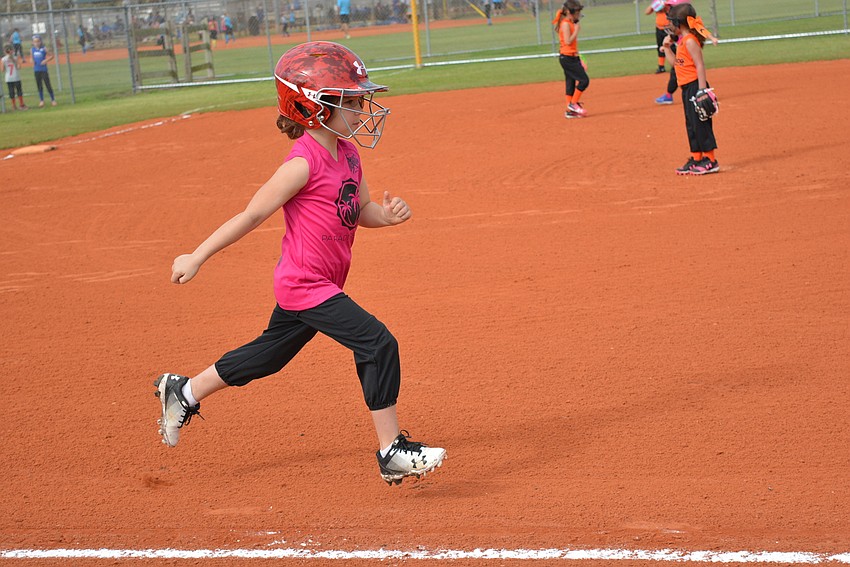 Miss Manatee Softball Lilly Russ runs to first base after hitting the ball.