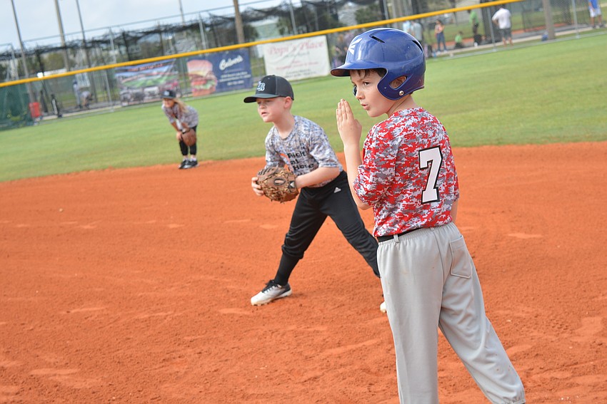 Lakewood Ranch Little League 7-year-old takes direction from a coach after making it to first base.  First baseman Eddy Thomas, 6, is ready for the next play.