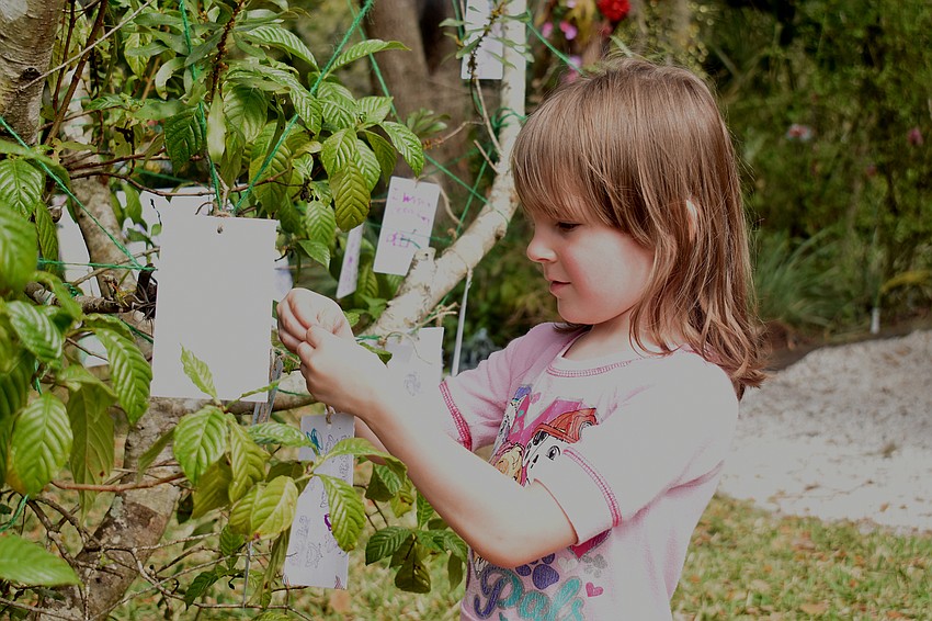 Michaela Tubbs ties her note to a tree.