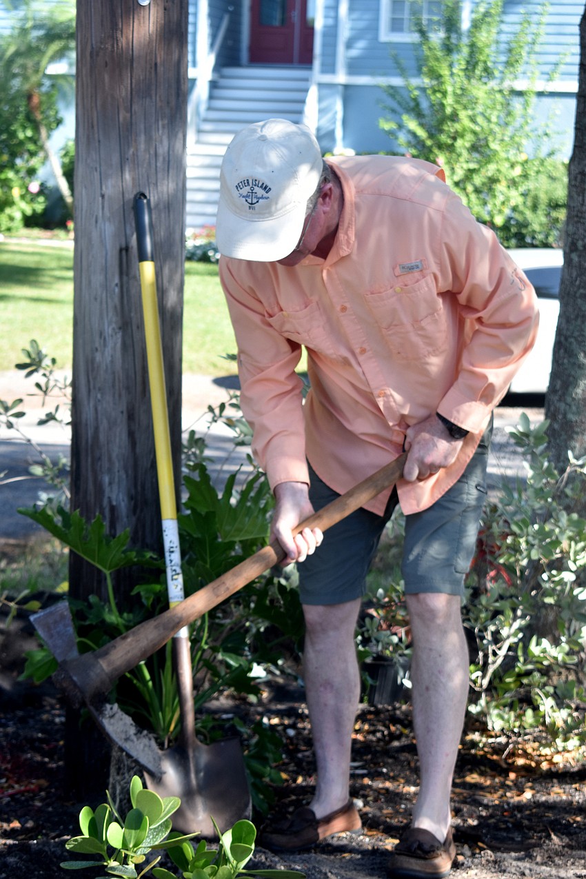 Steve Branham digs around a root while helping spruce up Public Works.