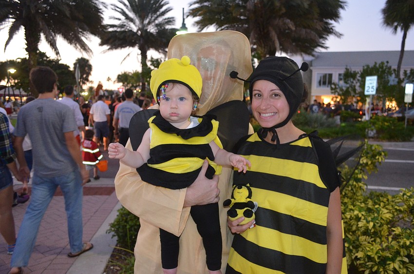 hawn and Andrew Hatcher with daughter Caroline Hatcher, 1, as bees and a beekeeper