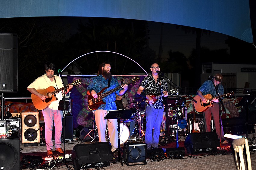 A band takes the stage as guests sit for dinner.