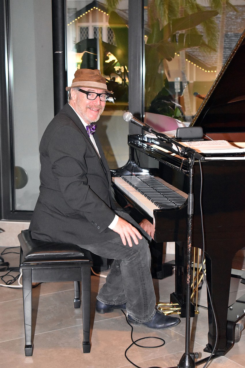 The pianist of Bill Buchman's Art of Jazz stops playing to smile for the camera.