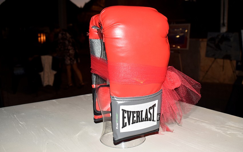 Red boxing gloves complete the “fight” theme.