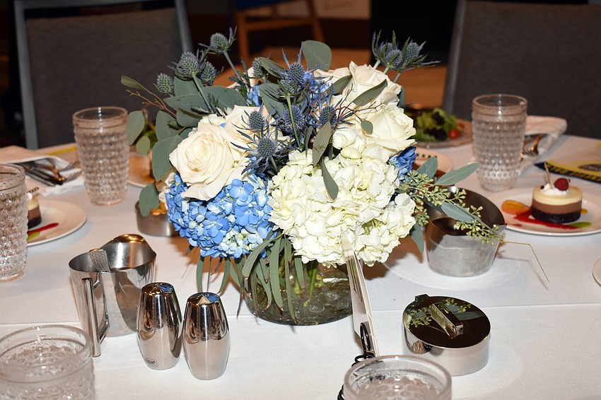 Each table featured a centerpiece comprised of blue and white flowers.
