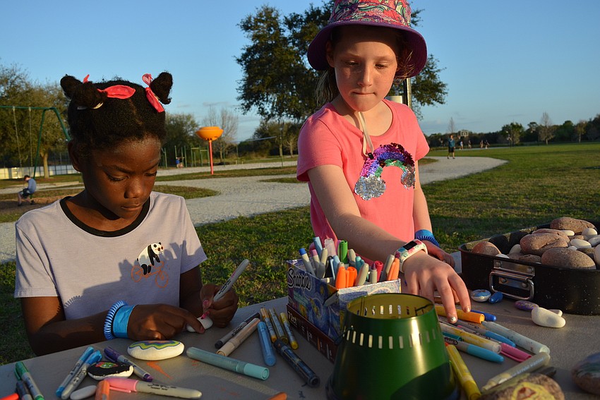 Six-year-old Haven Wiley and 7-year-old Payton Portale paint kindness rocks to share with the ice cream company on site.
