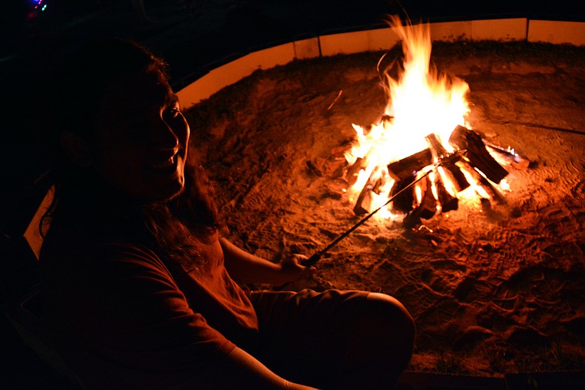 Antonio Hernandez tries out a s'mores roaster instead of toasting a marshmallow separately. The graham cracker, marshmallow and chocolate all went into the same roasting holder.