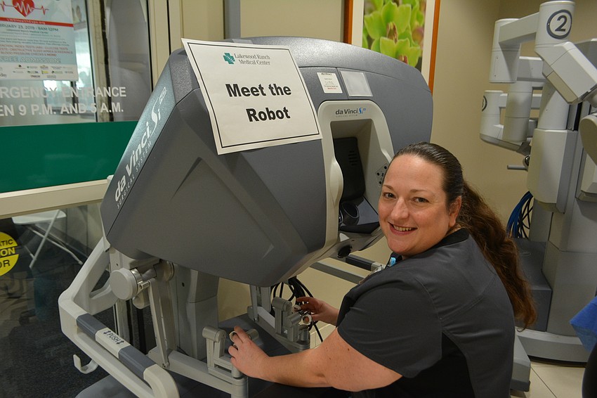 Elizabeth Burke, the robotic coordinator for Lakewood Ranch Medical Center, shows off the hospital's new Da Vinci surgical robot at the expo.