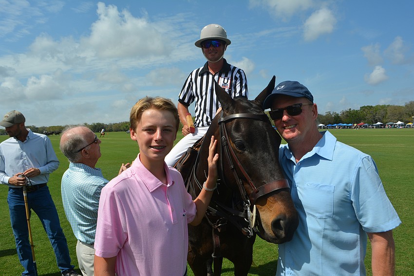 Max and Roger Pettingell of Coldwell Banker get up close and personal with referee Josh Shelton's horse before the match.