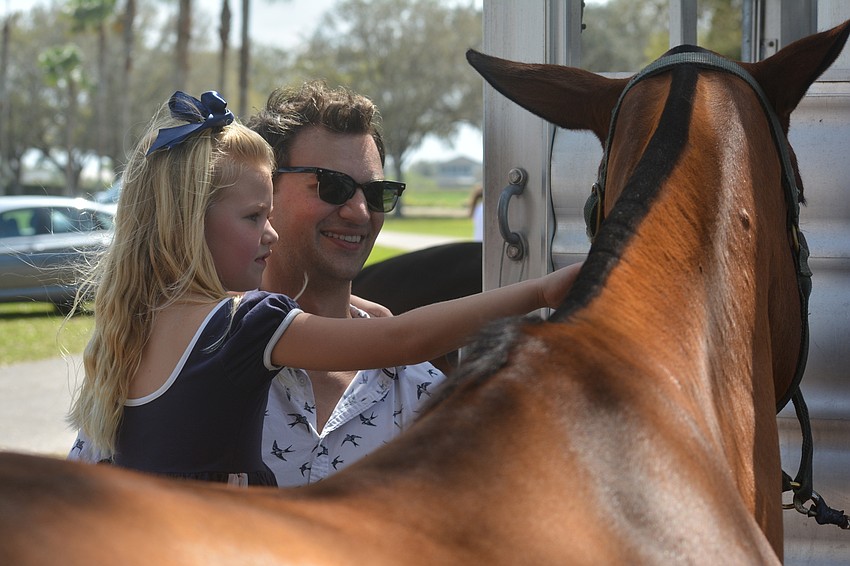 Six-year-old Minka Ernst and her dad, Judah Ernst, find out fans can get close to the polo stars.