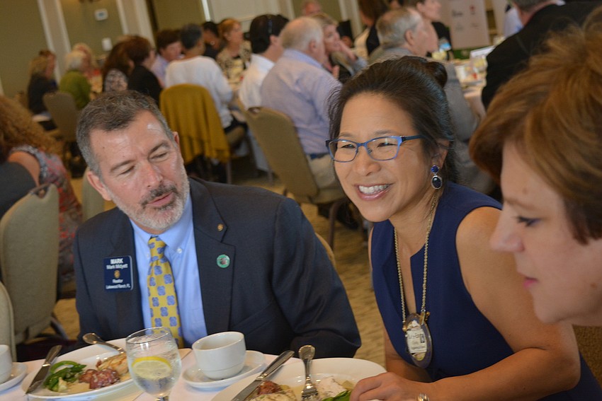 Rotary Club's Mark Midyett and Ivy Ventures Insurance's Lee-En Chung, of the Business Alliance, start introductions around the table.