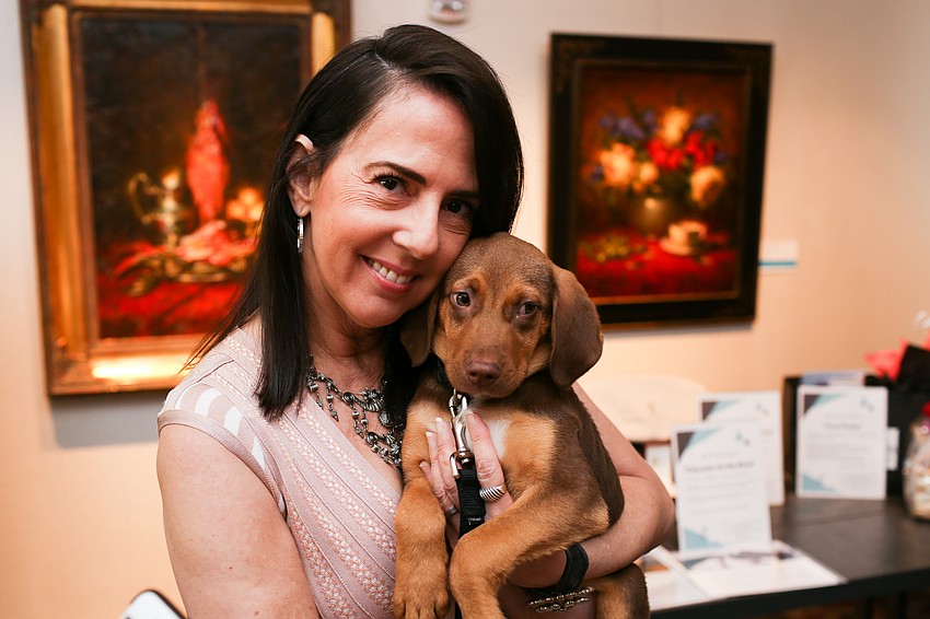 Clara Reynardus de Villanueva holds a puppy. Clara took home a puppy at last year's luncheon.