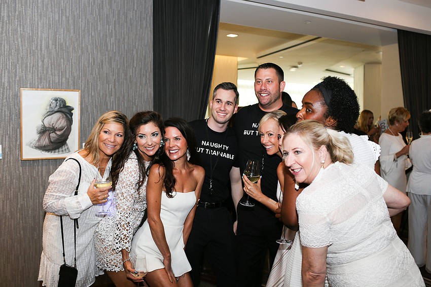 A group of guests pose for a photo with hot guys.