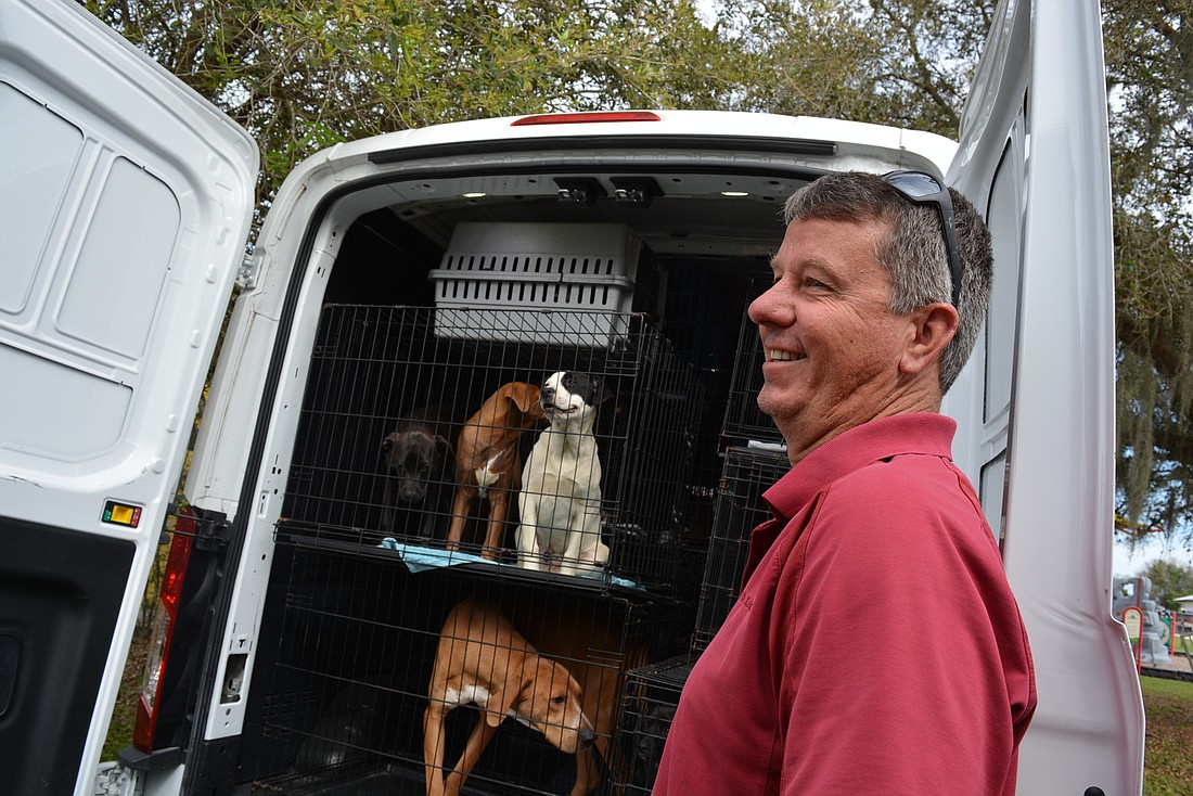 Nate&#39;s Honor Animal Rescue Director of Development Rob Oglesby smiles as he unloads a van full of 55 puppies taken from two shelters and two rescuers in Georgia. Nate&#39;s will find the animals homes.