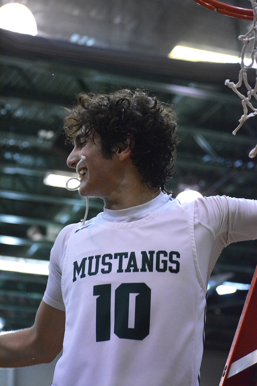 Lakewood Ranch junior guard Christian Perez holds a piece of the net in his mouth. Perez scored eight points against East Lake High.