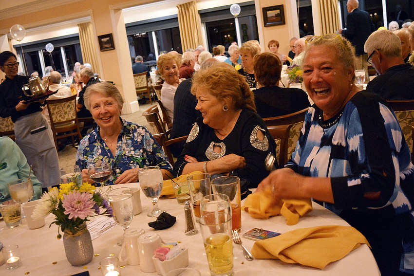 Ada Newton, Donna Bowdoin and Karen LeBarre laugh as Newton and Bowdoin try to balance spoons on their noses.