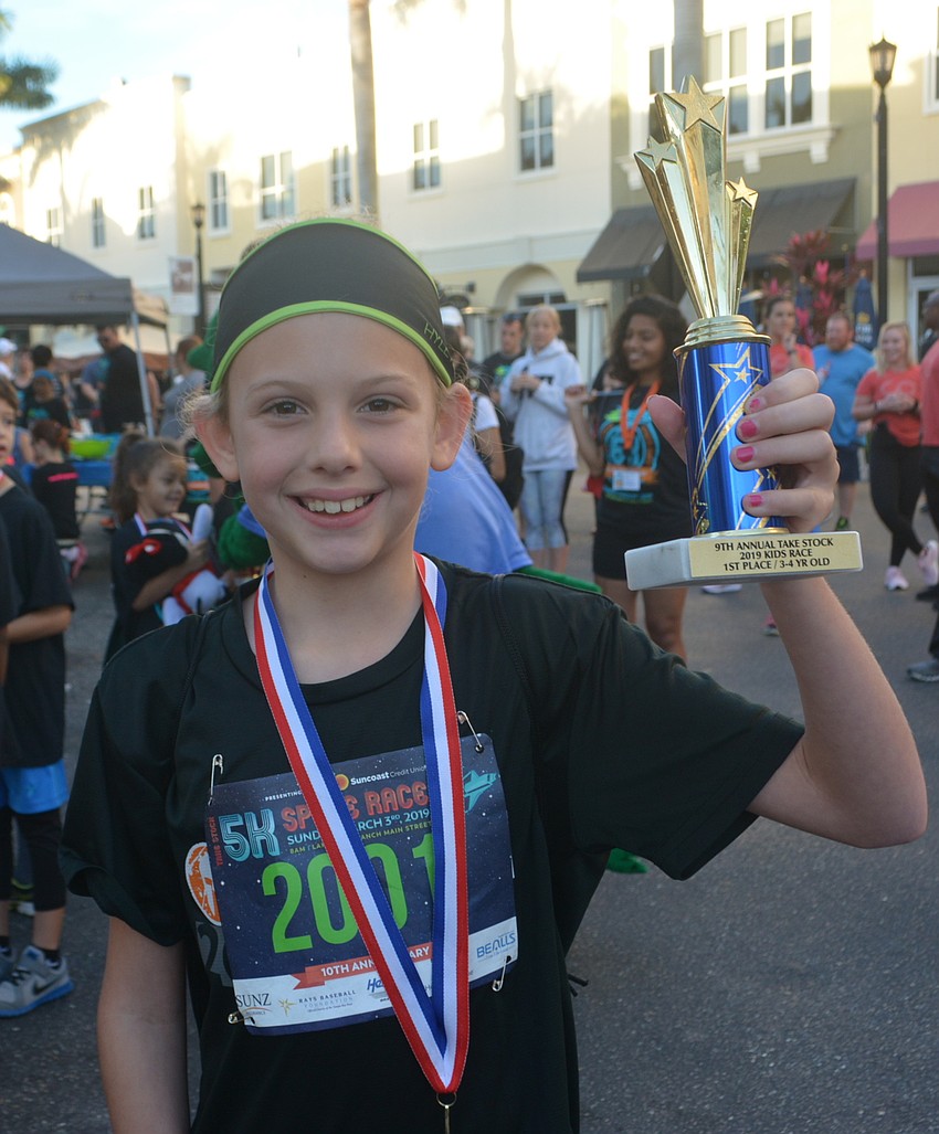 Bradenton 9-year-old Ellie Havell waves her first-place trophy.