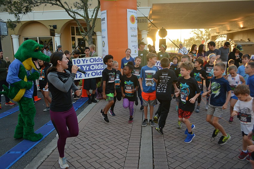 Cathy Fragale, a coach at Orangetheory of University Park, warms up the runners.