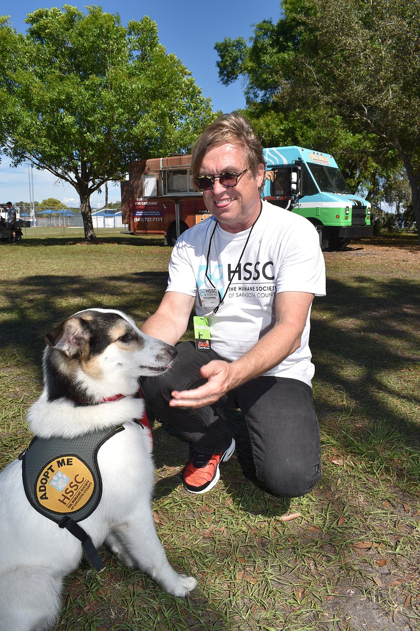 Clooney, a dog up for adoption at the Humane Society of Sarasota, plays with volunteer Alex Traugott.
